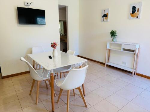 a dining room with a white table and white chairs at Dpto céntrico VGB in Villa General Belgrano
