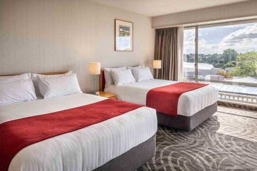 a hotel room with two beds and a large window at Waipuna Hotel & Conference Centre in Auckland