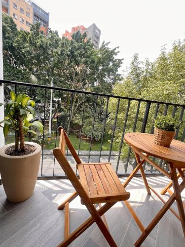 a balcony with a wooden table and a table at BIT by Simple stay in Medellín