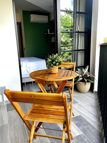 a wooden table and chairs on a balcony with a bed at BIT by Simple stay in Medellín