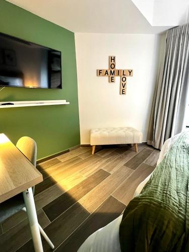 a bedroom with green walls and a bed and a tv at BIT by Simple stay in Medellín