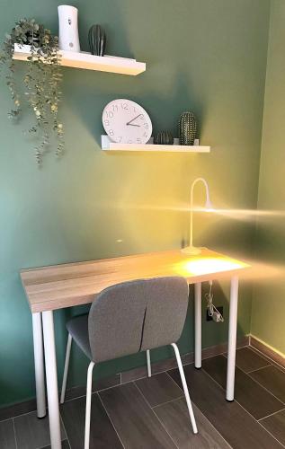 a desk with a chair and a clock on a wall at BIT by Simple stay in Medellín