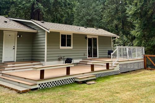 a house with a large wooden deck in front of it at The Mossy Nook A Cozy Escape in the Woods! in Issaquah