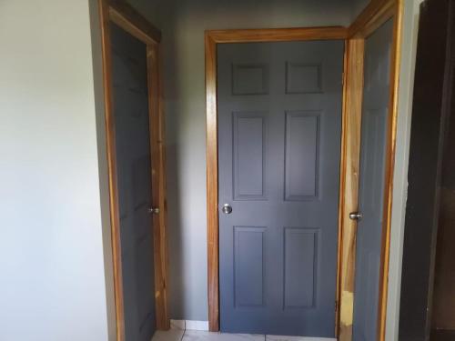 an empty hallway with a blue door in a room at Apartamento acogedor, minutos de Playa Camaguey #5 in Puerto Cortes