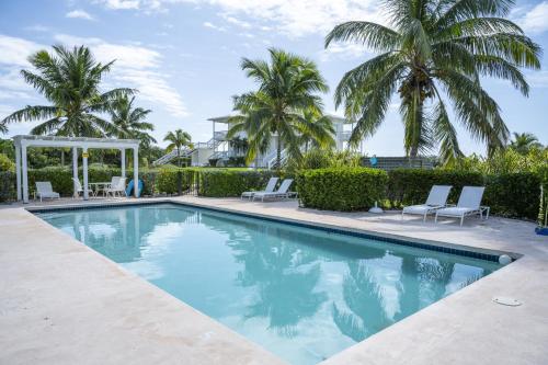 a swimming pool with chairs and palm trees at Buttonwood Reserve Main Lodge home in James Cistern