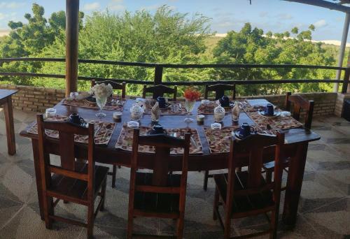 a wooden table with chairs and a tablecloth on a table at Pousada Zona do Kite Jeri in Jericoacoara