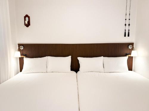 two beds in a hotel room with white pillows at Adam stay in Suyŏng