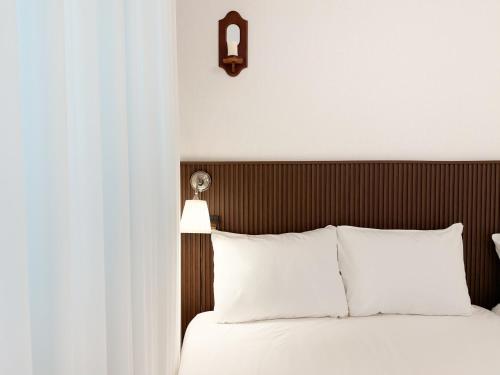 a bedroom with a white bed with a wooden headboard at Adam stay in Suyŏng