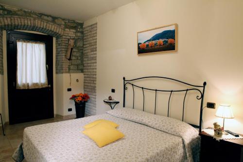 a bedroom with a bed with a yellow pillow on it at Il Casale della Quercia in Assisi