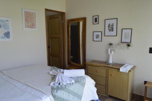 a bedroom with a bed and a dresser and a mirror at Coral De Fuego Isla Fuerte in Isla Fuerte