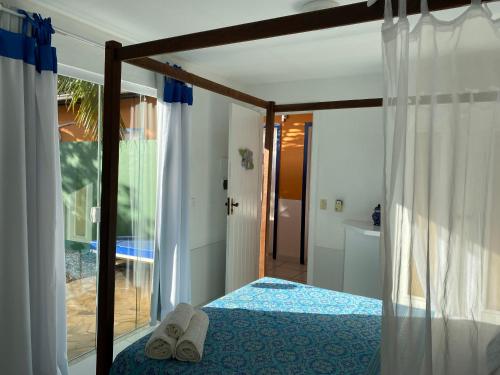 a bedroom with a bed with slippers on it at Villa Baobá Pousada & Spa in Búzios