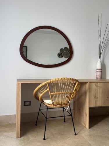 a wicker chair sitting in front of a mirror at Acogedor apartamento en Samaná con vista al mar in La Aguada