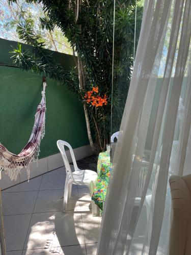 a patio with two white chairs and a hammock at Villa Baobá Pousada & Spa in Búzios