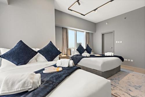 a bedroom with two beds with blue pillows at Desert Key - Platinum Apartments in Gate Tower, Al Reem Island in Abu Dhabi