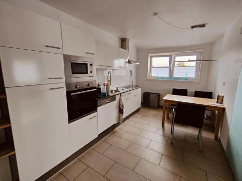 a kitchen with white cabinets and a table in it at Nele Daniel family in Waldeck
