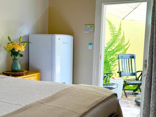 a room with a refrigerator and a patio with a chair at The Rivery Retreat, Choose from Luxury Guesthouse Cabin OR Poolside Suite in Lake Austin Hill Country in Austin