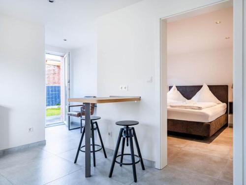 a bedroom with a bed and two bar stools at Holiday apartment with 2 bedrooms in Greetsiel