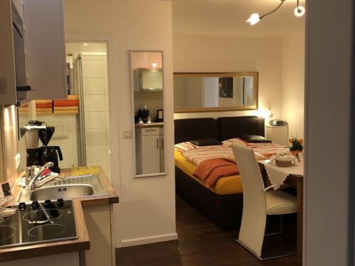 ein Schlafzimmer mit Bett und eine Küche mit Spüle in der Unterkunft Comfort Apartment House Regini in Norderney