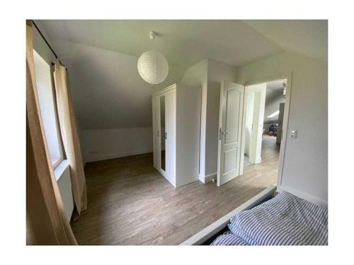 une pièce vide avec un lit et un miroir dans l'établissement Holiday apartment in Varel with swimming pool, à Dangast