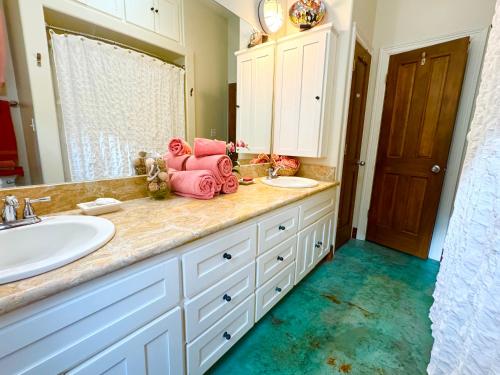 a bathroom with a sink and a counter with pink towels at The Rivery Retreat, Choose from Luxury Guesthouse Cabin OR Poolside Suite in Lake Austin Hill Country in Austin