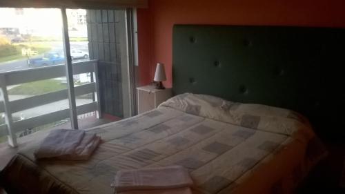 1 dormitorio con 1 cama grande y ventana grande en Departamento Mar de Plata 6 en Mar del Plata