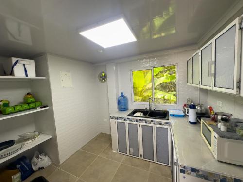 a small kitchen with a sink and a window at Posada Three Cay Suites in Providencia