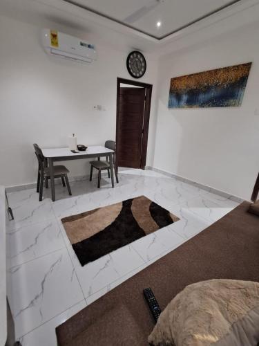 a living room with a table and a white wall at Cosdarl Homes in Nsawam
