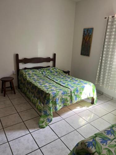 a bedroom with a bed and a tiled floor at Casa 2 quartos praia de Jacaraípe. in Serra