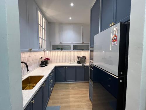 a kitchen with blue cabinets and a refrigerator at Middle Room Only in Bayan Lepas in Bayan Lepas