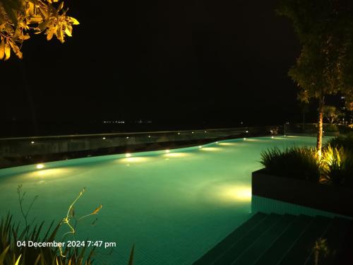 a swimming pool at night with lights on it at Middle Room Only in Bayan Lepas in Bayan Lepas