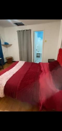 a bedroom with a red blanket on a bed at Hostal centro in La Serena