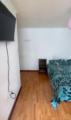 a bedroom with a bed and a wooden floor at Hostal centro in La Serena