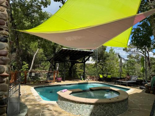 a yellow umbrella over a swimming pool with a table at The Rivery Retreat, Choose from Luxury Guesthouse Cabin OR Poolside Suite in Lake Austin Hill Country in Austin
