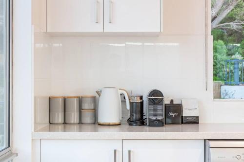 a kitchen counter with a coffee maker on a shelf at Idlehour - Charming Retreat by Yallingup Beach in Yallingup