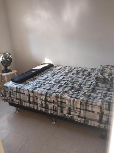 Una cama en una habitación con una manta. en Casa Aconchegante, en Nova Odessa