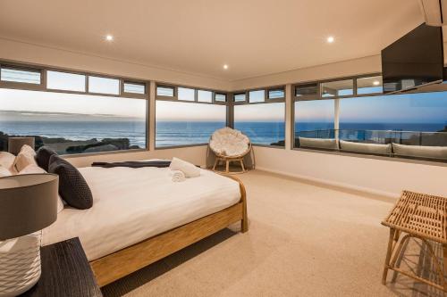 a bedroom with a large bed with a view of the ocean at Idlehour - Charming Retreat by Yallingup Beach in Yallingup