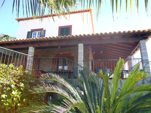 a house with a balcony in front of it at Casa da Rainha in Calheta