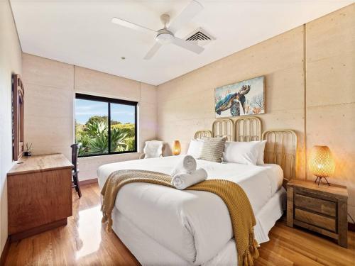 a bedroom with a large white bed and a window at La Dimora - Tranquil Retreat Where Bush Meets Beach in Prevelly