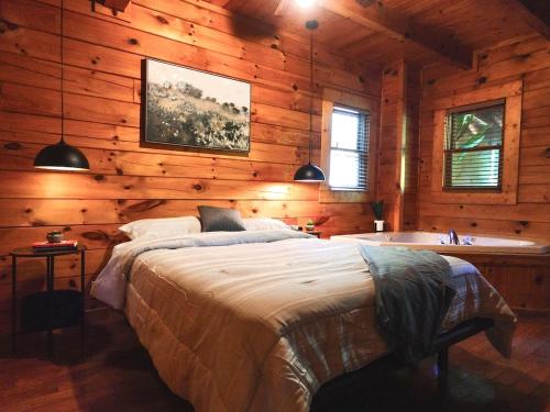 1 dormitorio con cama y bañera en una cabaña en Smoky Haven Cabin, en Sevierville