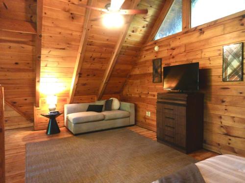 Habitación con sofá y TV en una cabina. en Smoky Haven Cabin, en Sevierville