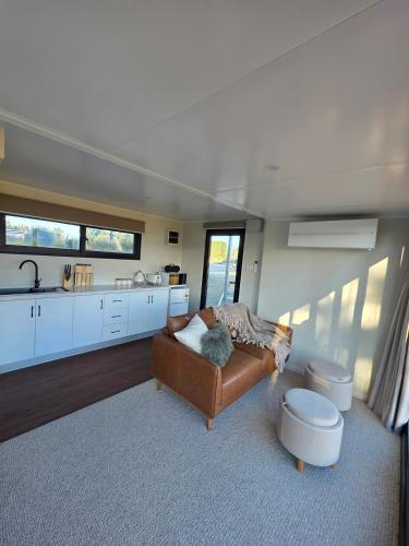 a living room with a couch and a kitchen at Modern studio overlooking Alexandra, Central Otago in Alexandra