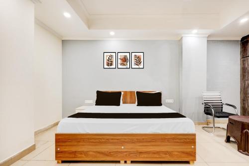 a bedroom with a large bed and a chair at HOTEL O BLUE DIAMOND STAY in Noida