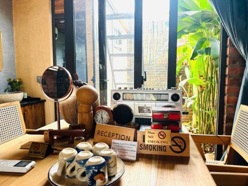 a table with coffee cups and a radio on it at Duong Lam Eco Home in Sơn Tây
