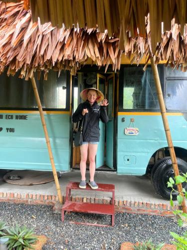 a woman standing on a step in front of a bus at Duong Lam Eco Home in Sơn Tây
