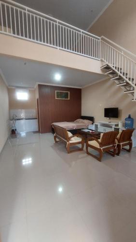 a large room with a bed and a staircase at Family Guest House in Sumedang Utara