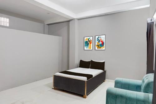 a bedroom with a bed and a blue chair at Hotel O Raj Palace in Bāra Banki