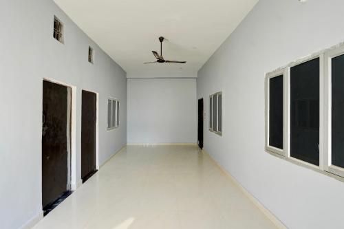 an empty room with white walls and windows at Hotel O Raj Palace in Bāra Banki