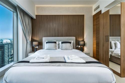 a bedroom with a large bed with two towels on it at Desert Key - Platinum Apartments in Gate Tower, Al Reem Island in Abu Dhabi