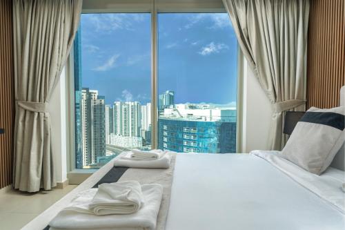 a bedroom with a large window with a view of a city at Desert Key - Platinum Apartments in Gate Tower, Al Reem Island in Abu Dhabi