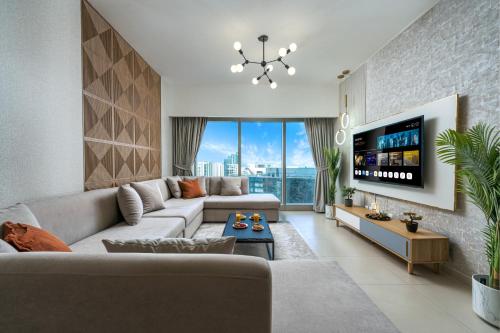 a living room with a couch and a tv at Desert Key - Platinum Apartments in Gate Tower, Al Reem Island in Abu Dhabi